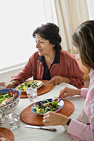 Family older woman and younger woman sharing meal at table.